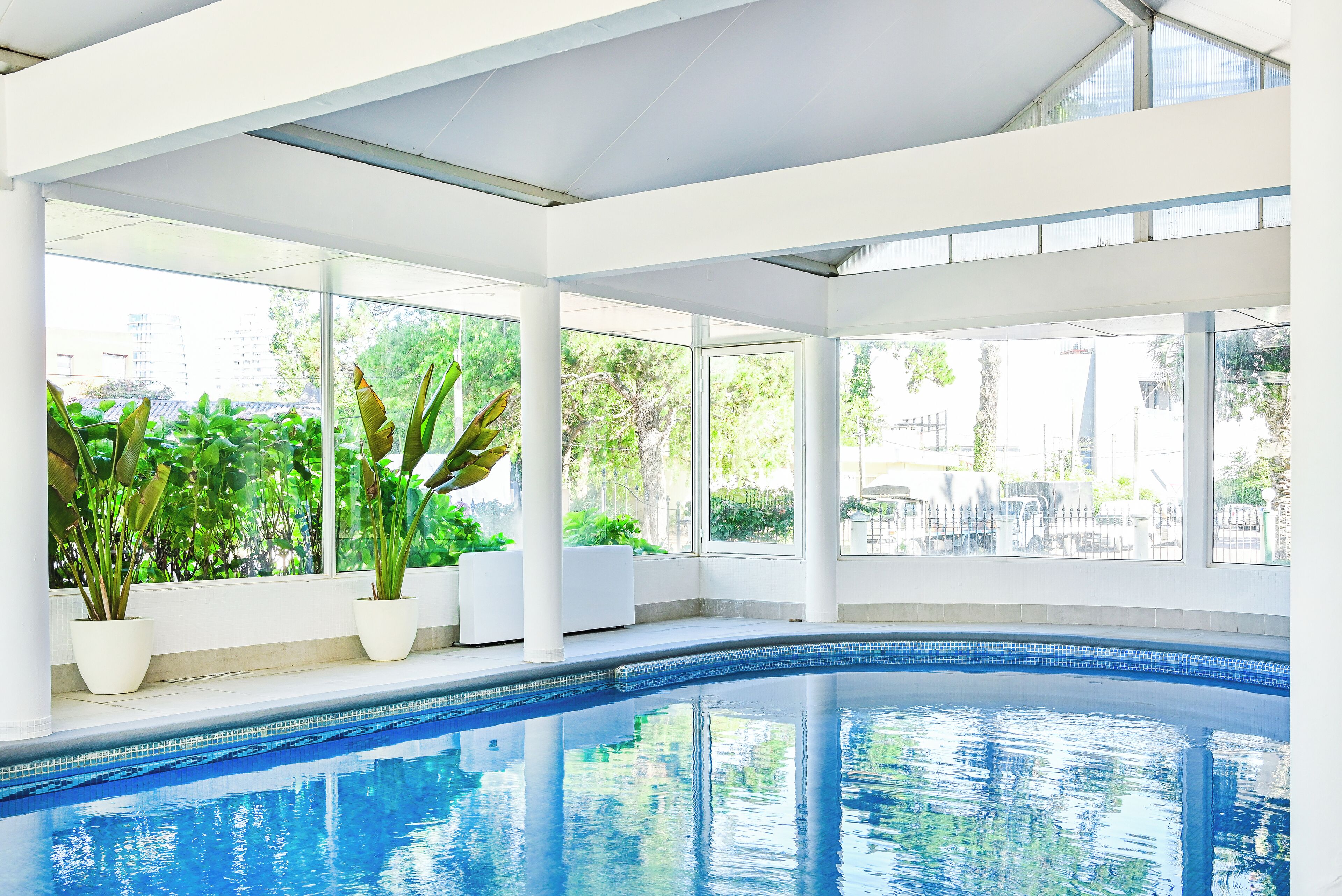 Una piscina al aire libre, sillones reclinables de piscina