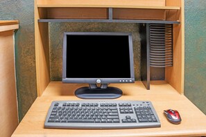 A computer desk with a keyboard, a mouse, and a monitor.