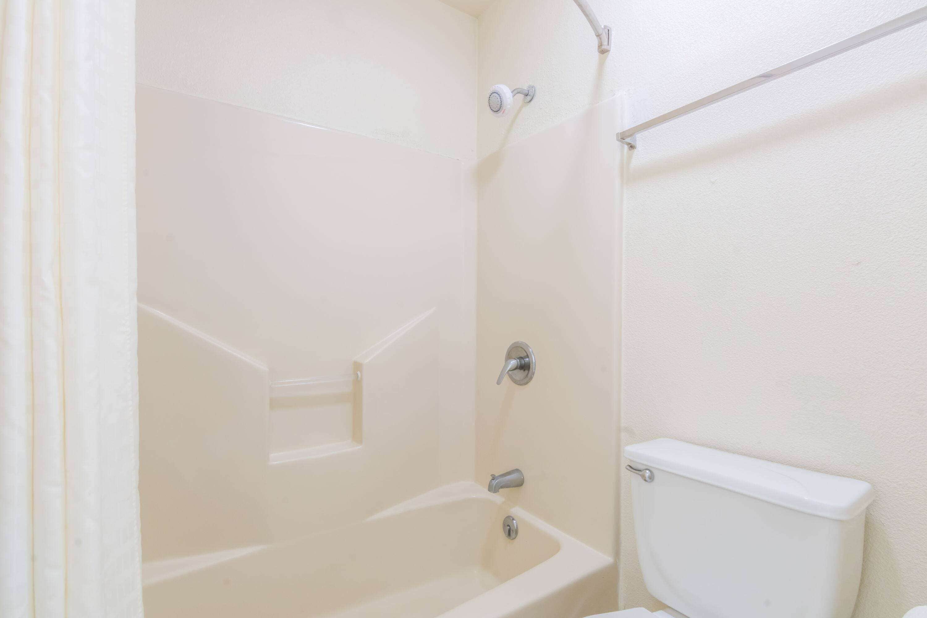 Une salle de bain avec une baignoire, des toilettes et une douche.