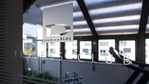 Un logotipo con el texto 'DOM CARLOS FITNESS CLUB' en un escaparate.