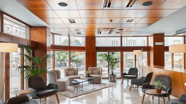 Un vestíbulo amplio con muebles modernos, ventanas grandes y suelo pulido.