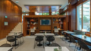 Un interior moderno con una escalera, un televisor y varias zonas de estar.