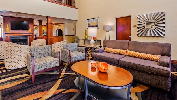 A hotel lobby with a fireplace, seating area, and a gift shop sign.