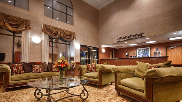 A spacious lobby with a large seating area, a reception desk, and a decorative wall with framed pictures.