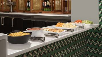 A buffet with various food items and a bar area with liquor bottles.