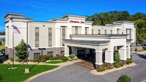 A Hampton Inn hotel with a modern facade, a welcoming entrance, and a well-maintained lawn.
