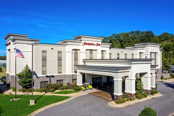 A Hampton Inn hotel with a modern facade, a welcoming entrance, and a well-maintained lawn.
