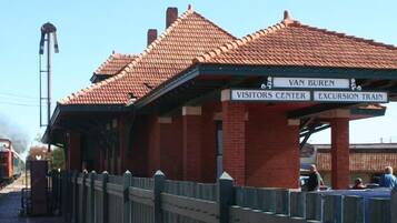 A brick building with a red-tiled roof labeled "Van Buren Visitors Center Excursion Train."