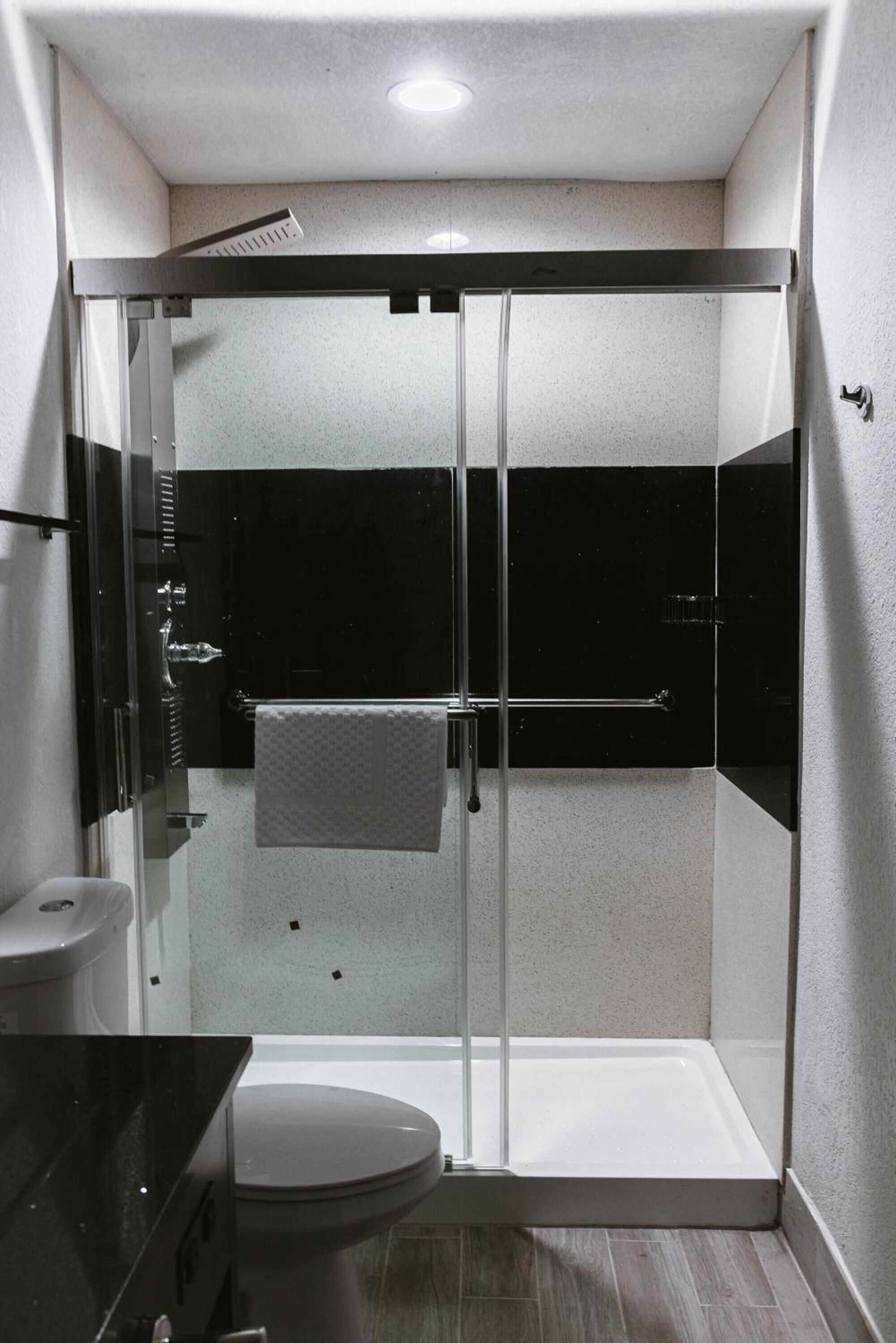 Une salle de bain compacte avec une douche à parois de verre, des toilettes et un lavabo.