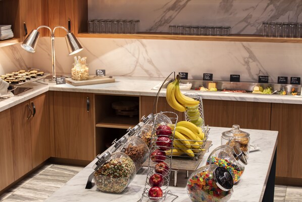 A buffet setup with various food items and a fruit display. - Louisville Marriott Downtown (Louisville)