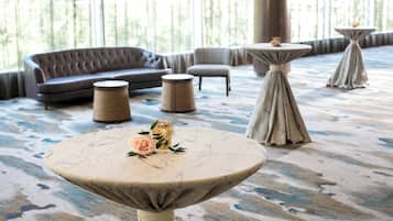 A modern lounge area with a sofa, two round tables, and a decorative centerpiece.