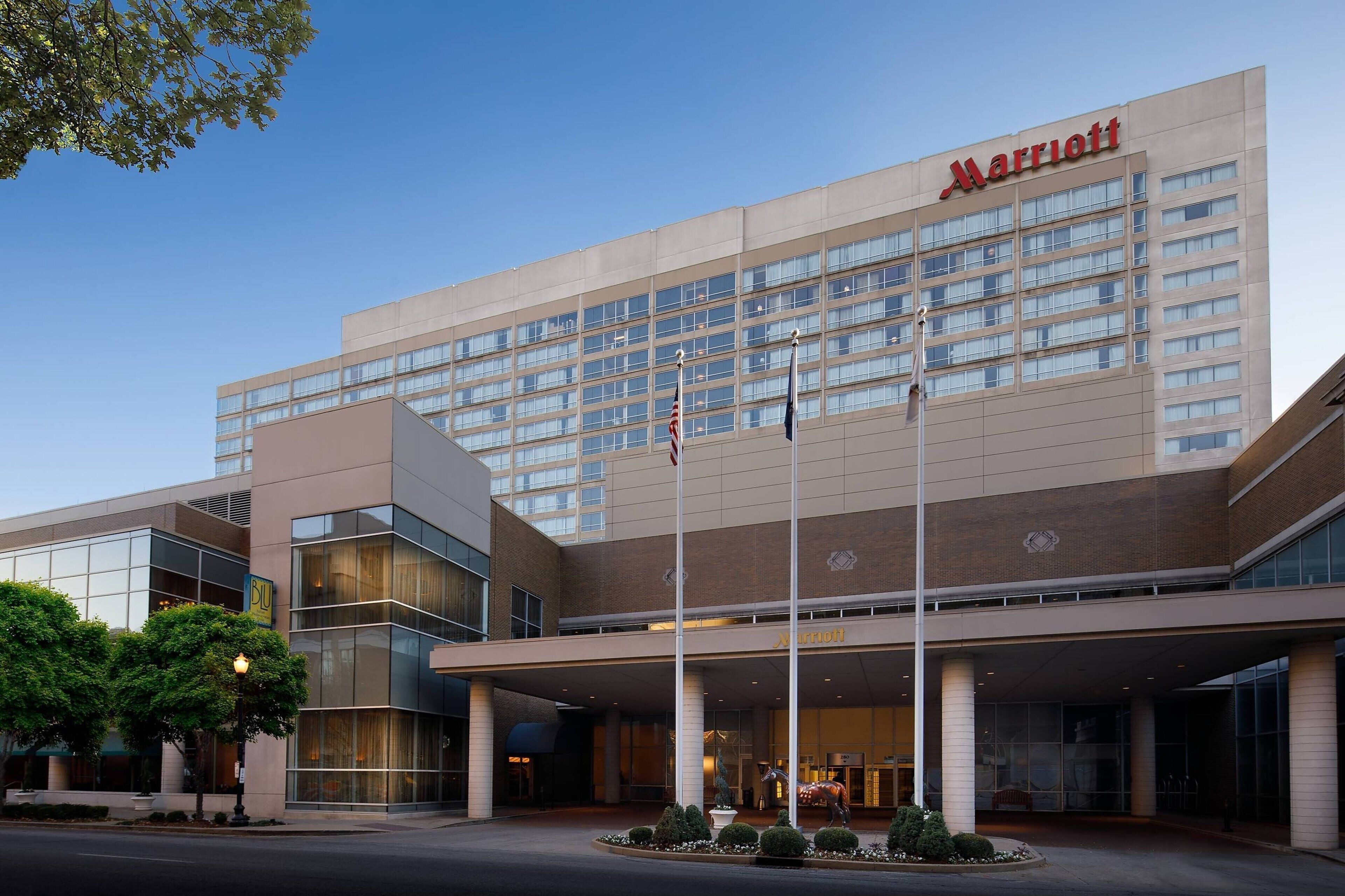 Un hotel Marriott con fachada moderna, amplias ventanas y un área de entrada bien cuidada.
