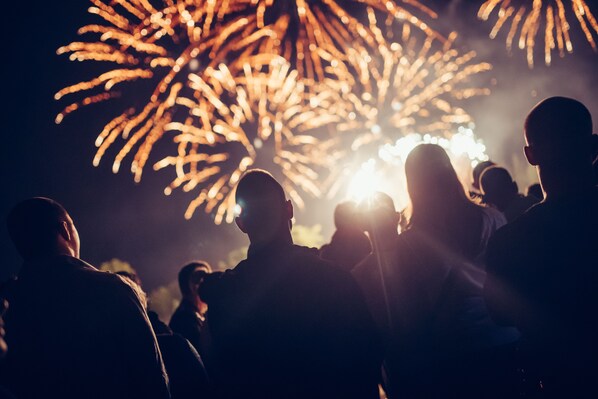 Siluetas de personas mirando fuegos artificiales.
