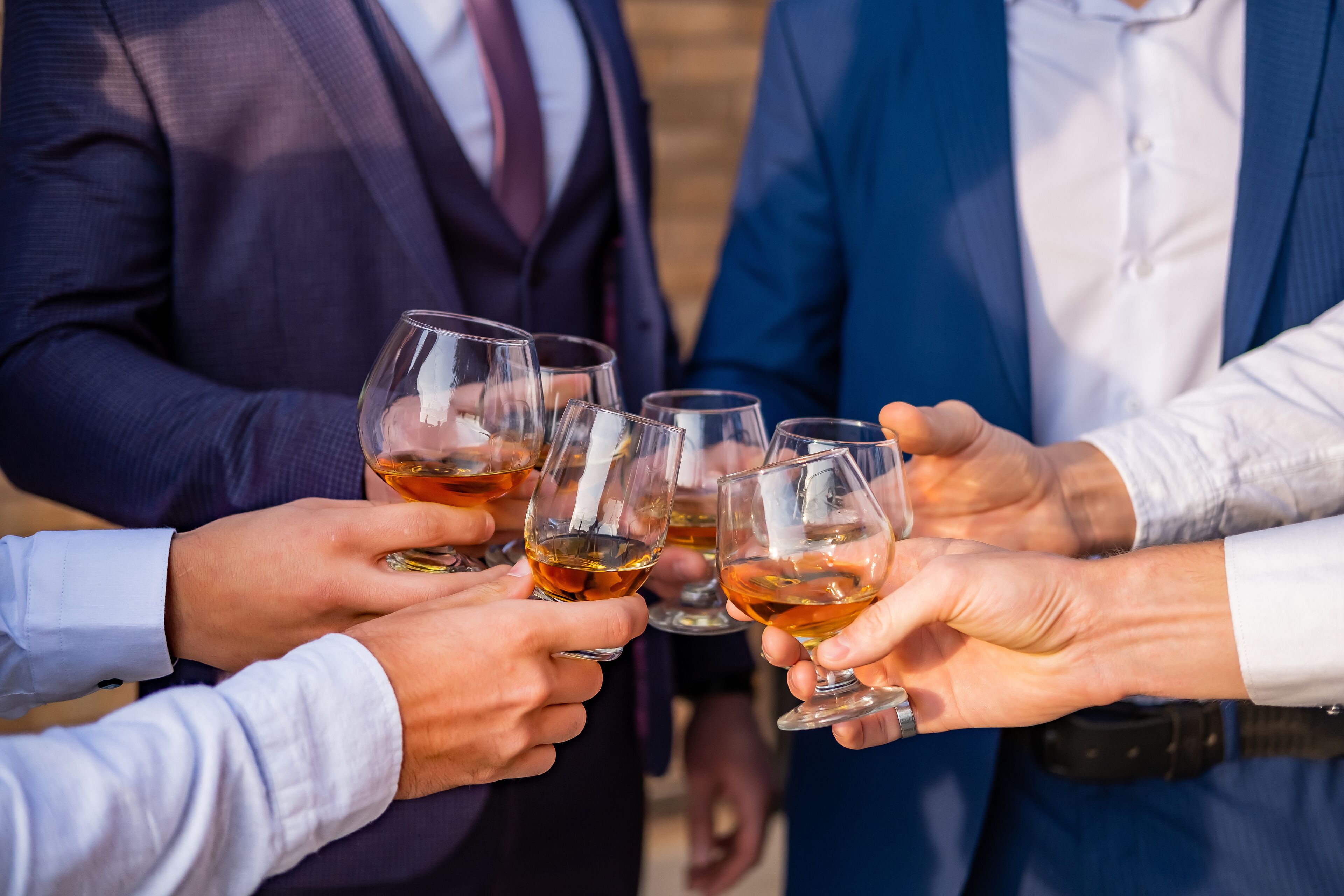 A group of people toasting with glasses of a beverage.