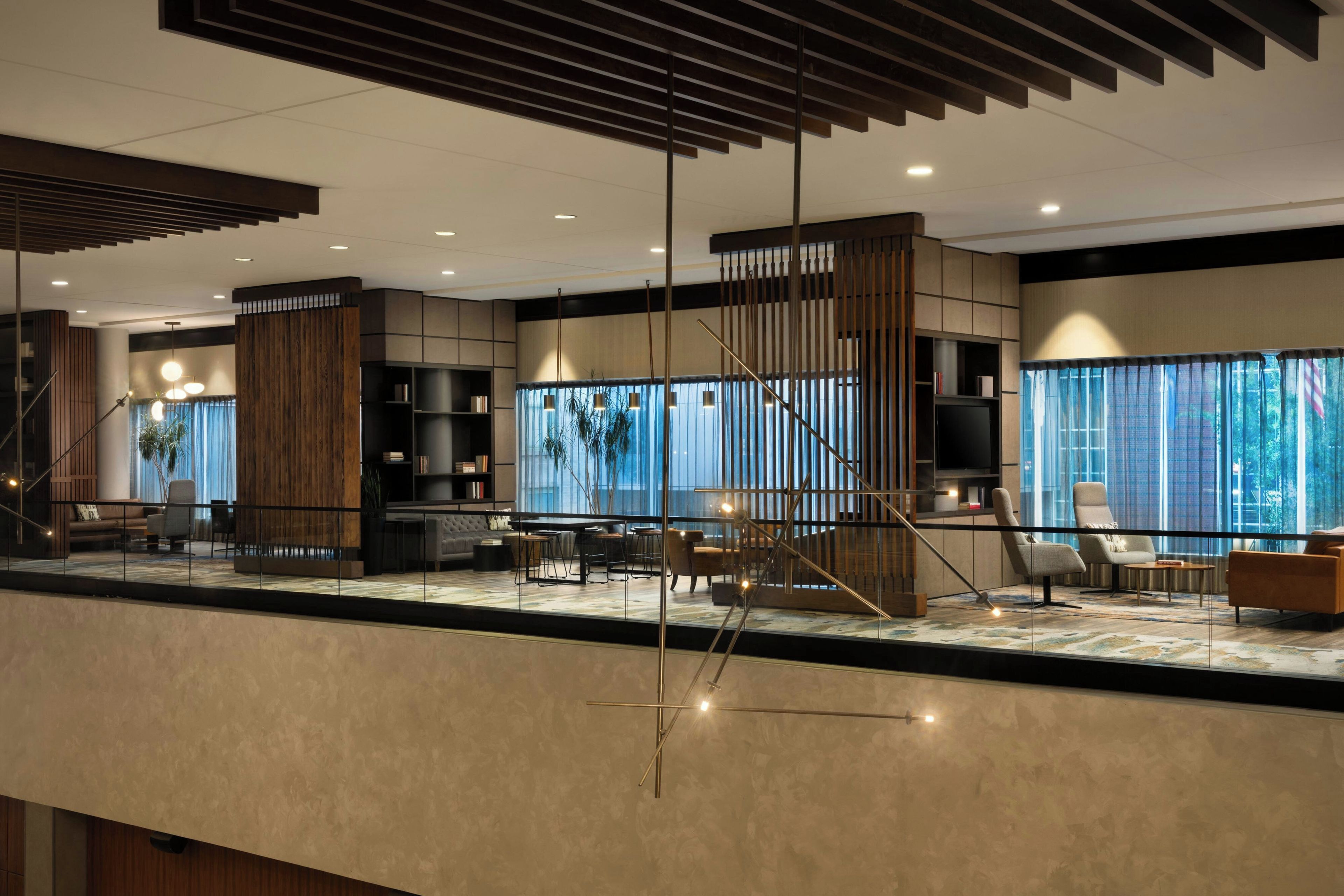 A modern interior with a dining area, seating, and a large window with curtains.