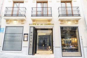 Entrada de hotel con un letrero que dice "Puerta de las Granadas".