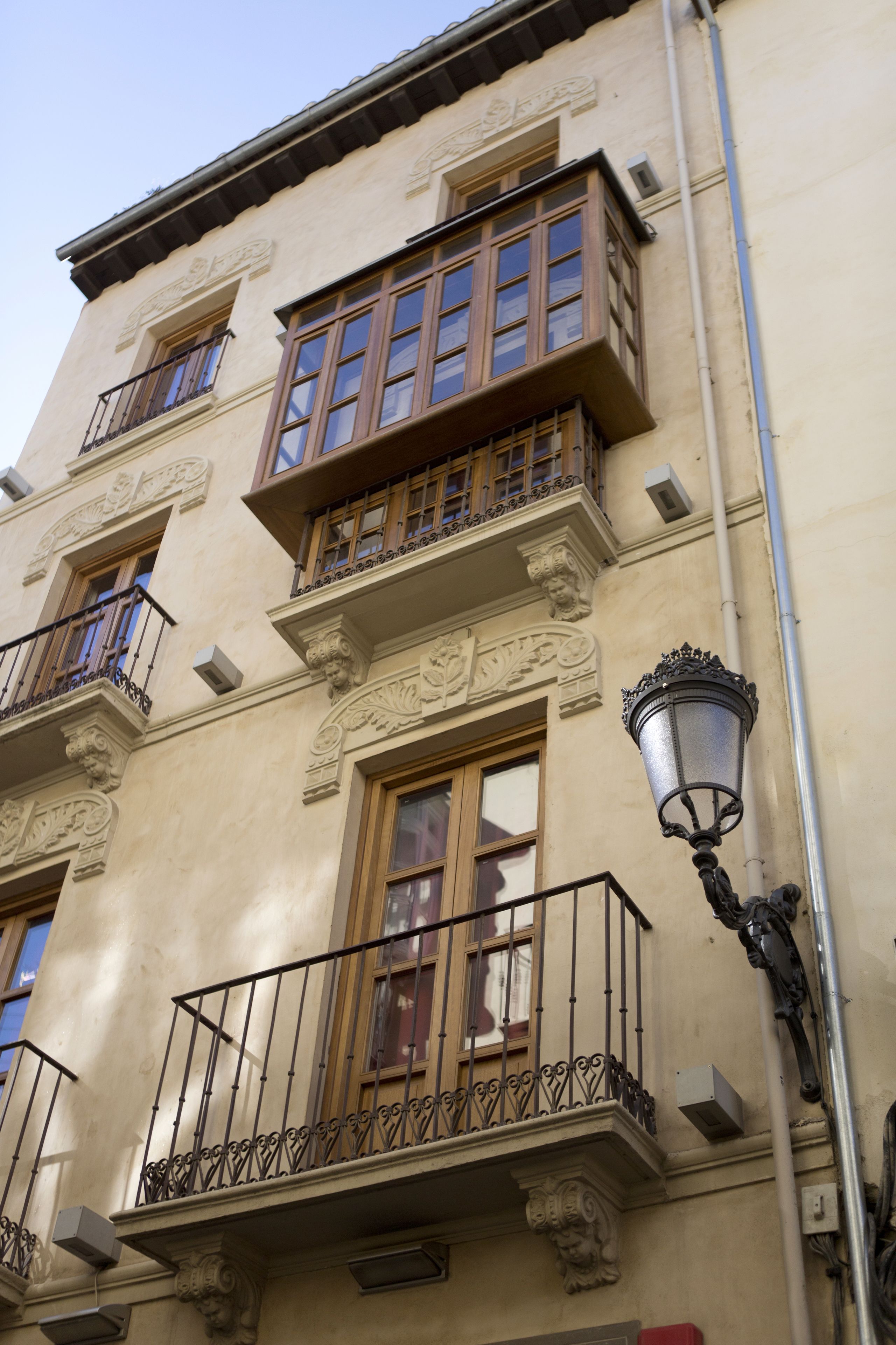 Ein Gebäude mit aufwendigen Balkonen, großen Fenstern und einer Straßenlaterne.