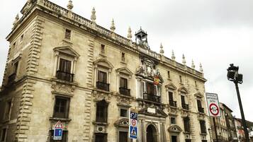 Un edificio histórico con arquitectura clásica, que presenta balcones ornamentados y una entrada destacada.