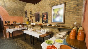 Una mesa de buffet con diferentes alimentos y una pared de ladrillo rústica.