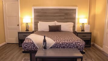 Ein Hotelzimmer mit einem großen Bett, Nachttischen, einem Schreibtisch und einem Stuhl.