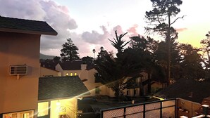 A residential area with houses, a fenced yard, and a sunset sky.