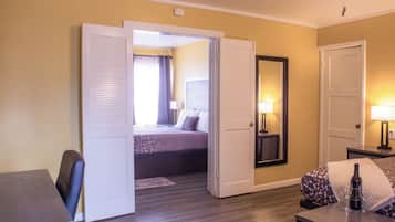 Een hotelkamer met een bed, een bureau, een stoel, een tafel en een spiegel.