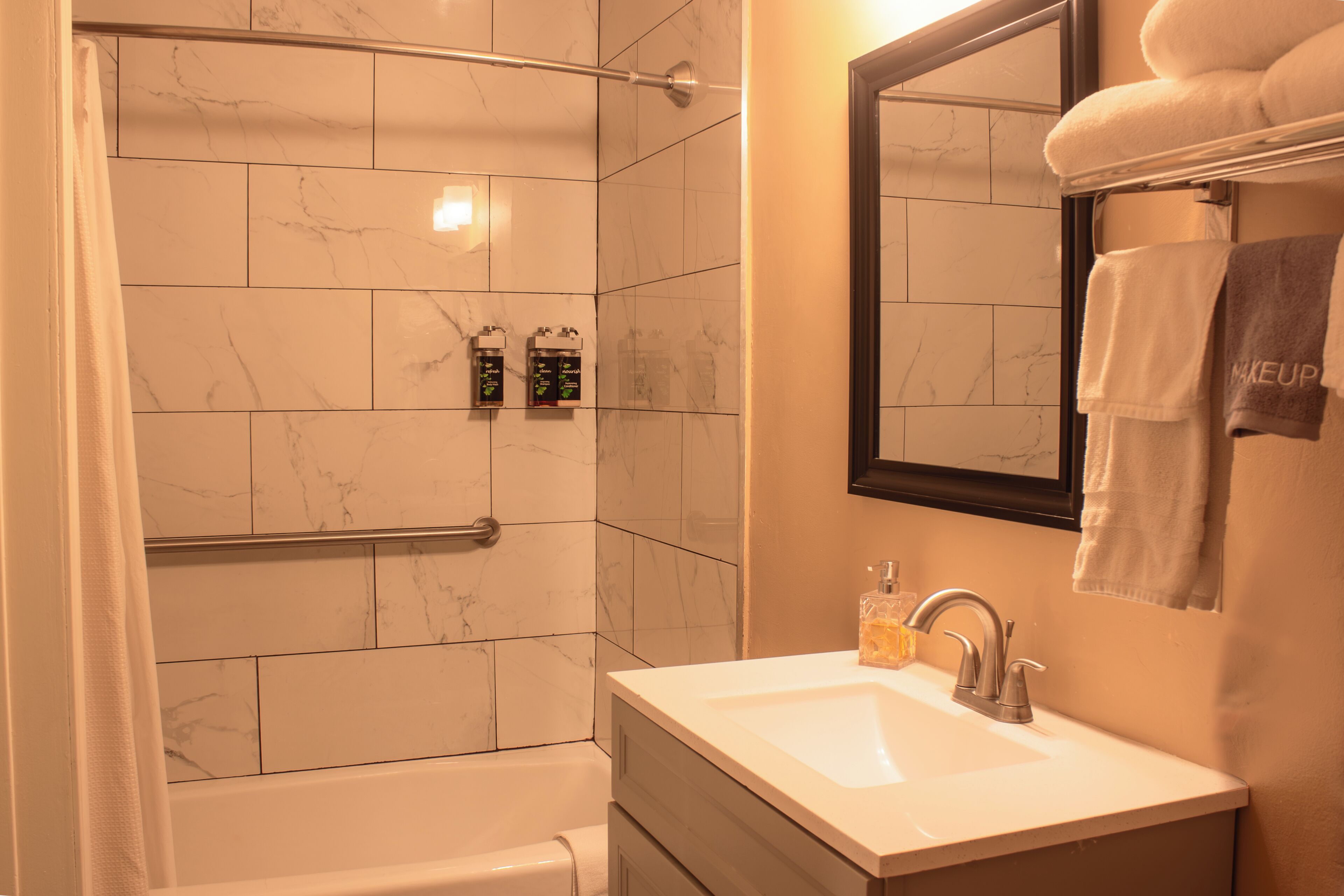 Une salle de bain avec une douche, un lavabo et un miroir.