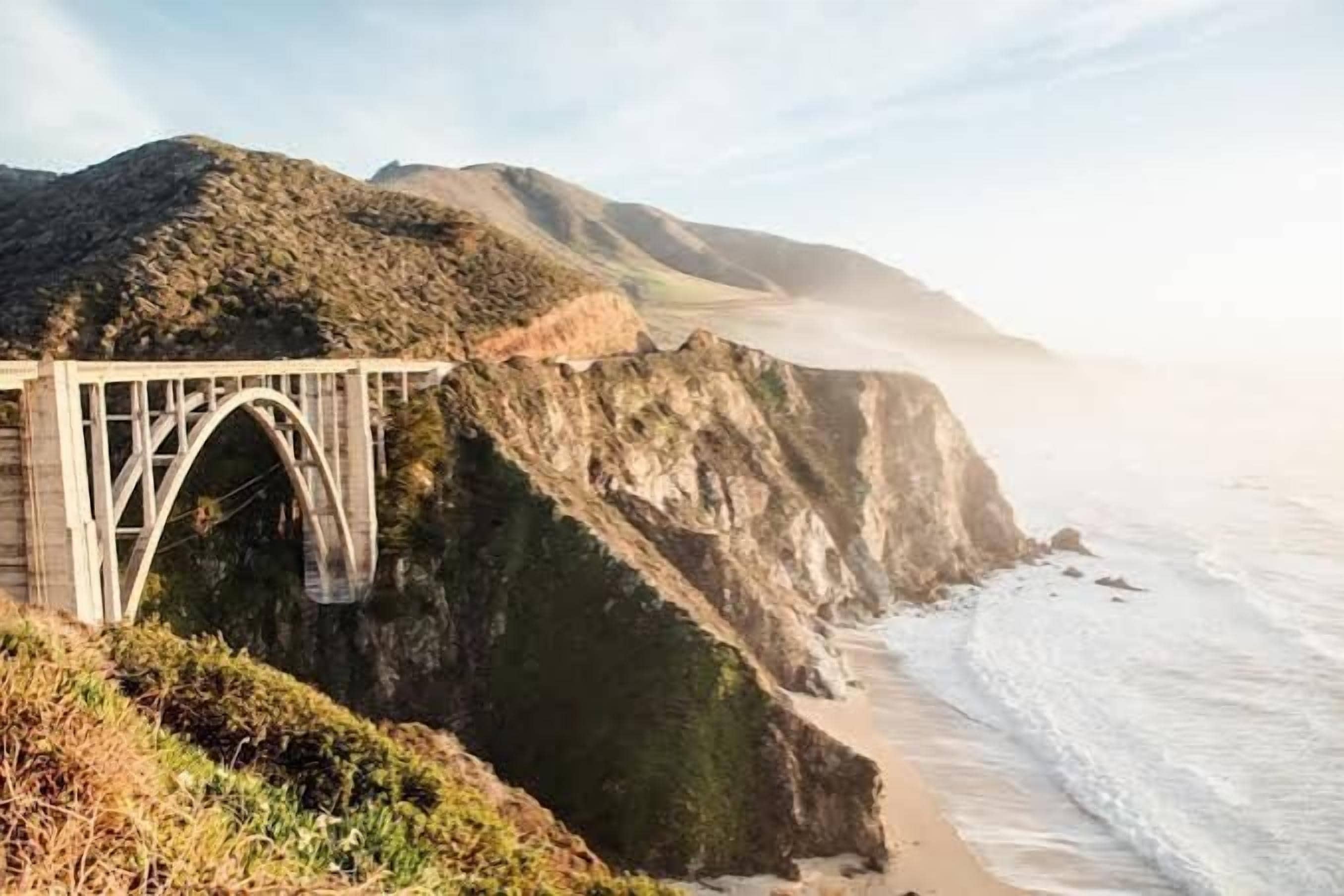 A bridge over a coastal cliff with a view of the ocean.