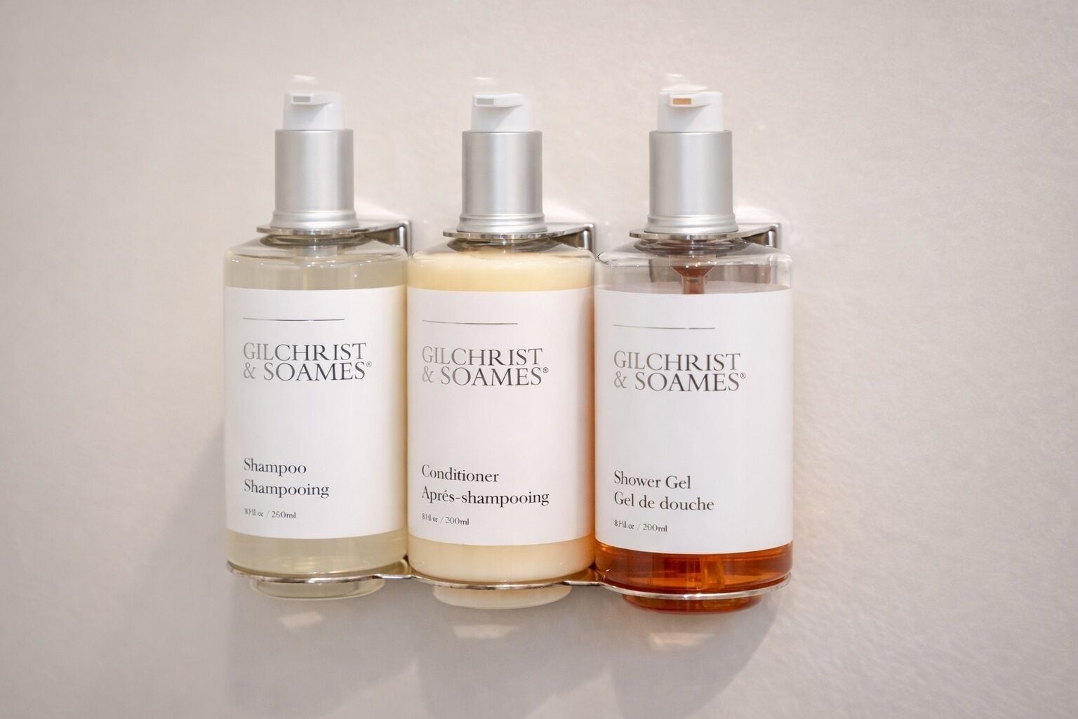 Three Gilchrist & Soames products: shampoo, conditioner, and shower gel.