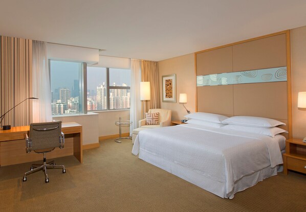 A hotel room with a large bed, a desk, a chair, and a view of the cityscape through the window. - Four Points by Sheraton Shenzhen (Shenzhen)