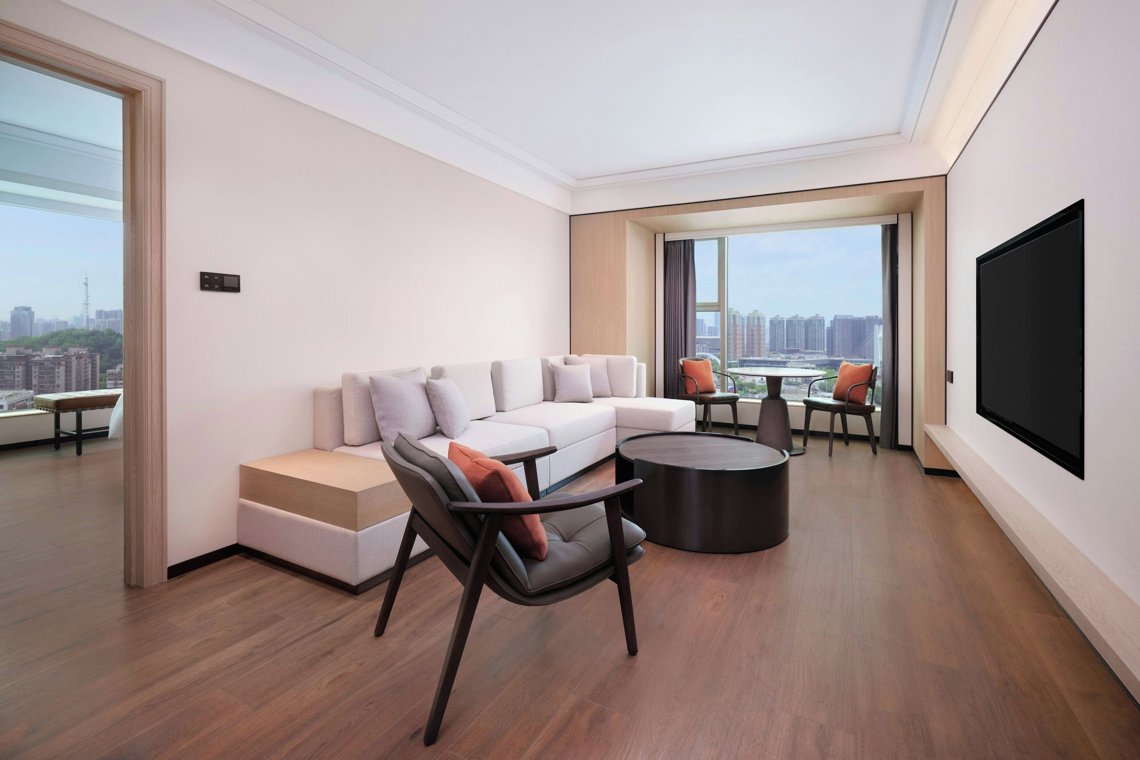 Una sala moderna con un sofá modular, una mesa de centro y un televisor de pantalla plana.