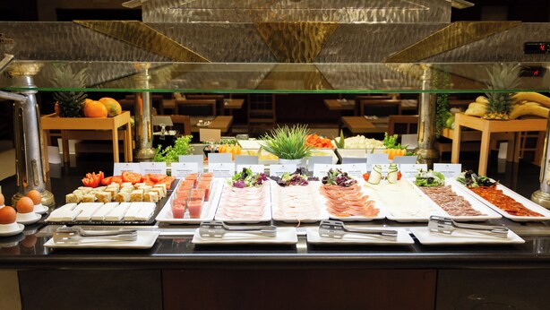 A buffet with various food items and utensils.