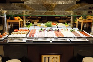 A buffet with various food items and utensils.