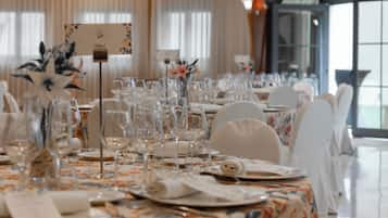 A banquet table set with glassware, plates, and napkins, with floral centerpieces and a sign indicating the table number.