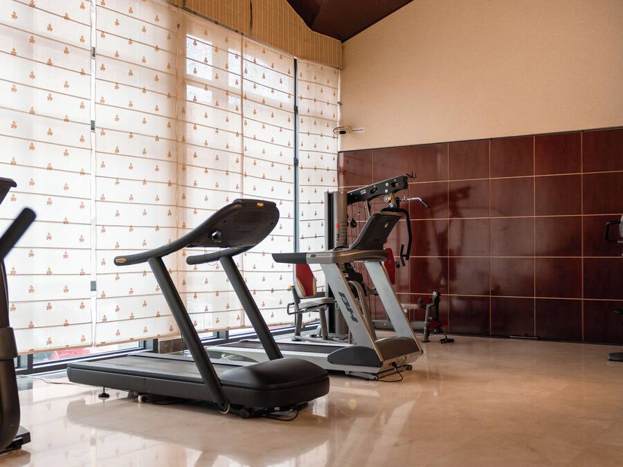 Un gimnasio con cintas de correr y equipo de ejercicio.