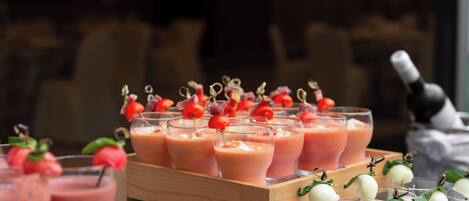 A tray of fruit-topped beverages, likely smoothies or cocktails, arranged on a wooden table.