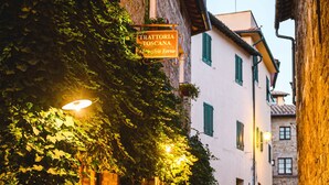 A narrow cobblestone street with a restaurant named "Trattoria al Vecchio Forno" and a sign indicating "Giardino" (garden). -  Hotel Palazzo del Capitano Wellness & Relais - Luxury Borgo Capitano Collection (San Quirico d'Orcia)