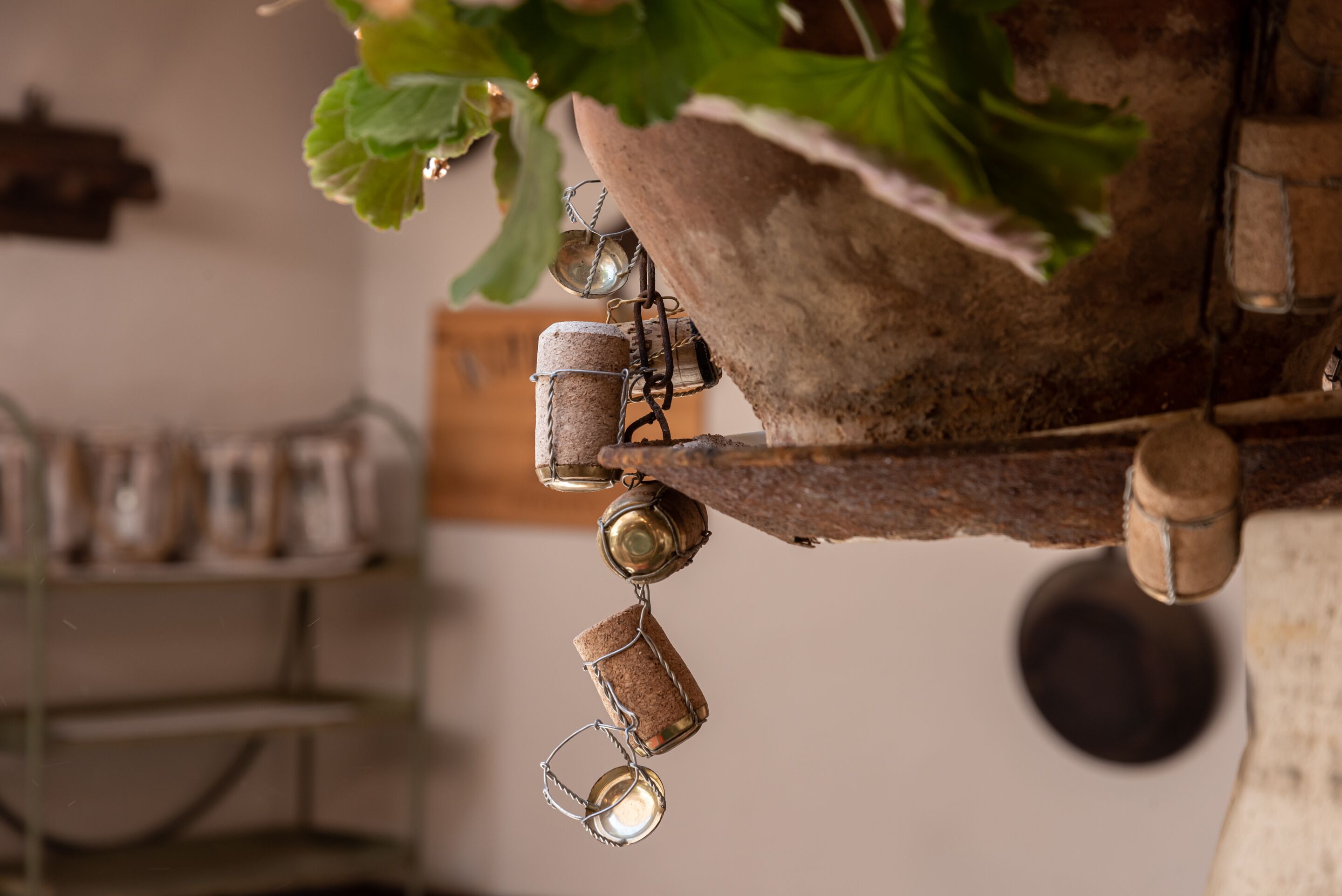 A rustic kitchen with a hanging pot rack and various kitchen utensils.