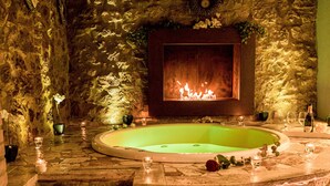 A stone-walled room with a large bathtub, a fireplace, and a set of stone steps leading to the tub. -  Hotel Palazzo del Capitano Wellness & Relais - Luxury Borgo Capitano Collection (San Quirico d'Orcia)