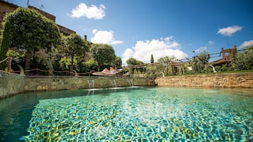 Una piscina al aire libre de temporada, sombrillas