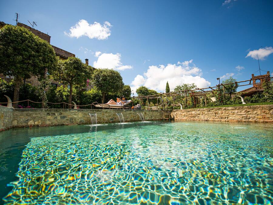 Una piscina al aire libre de temporada, sombrillas