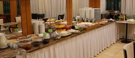 A buffet setup with various food items and beverages.