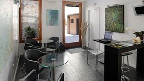 A modern interior with a dining area, a workspace, and a view of the outside. - Ca' Pozzo Inn (Venice)