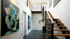 A modern interior with a staircase, artwork on the walls, and a minimalist design. - Ca' Pozzo Inn (Venice)