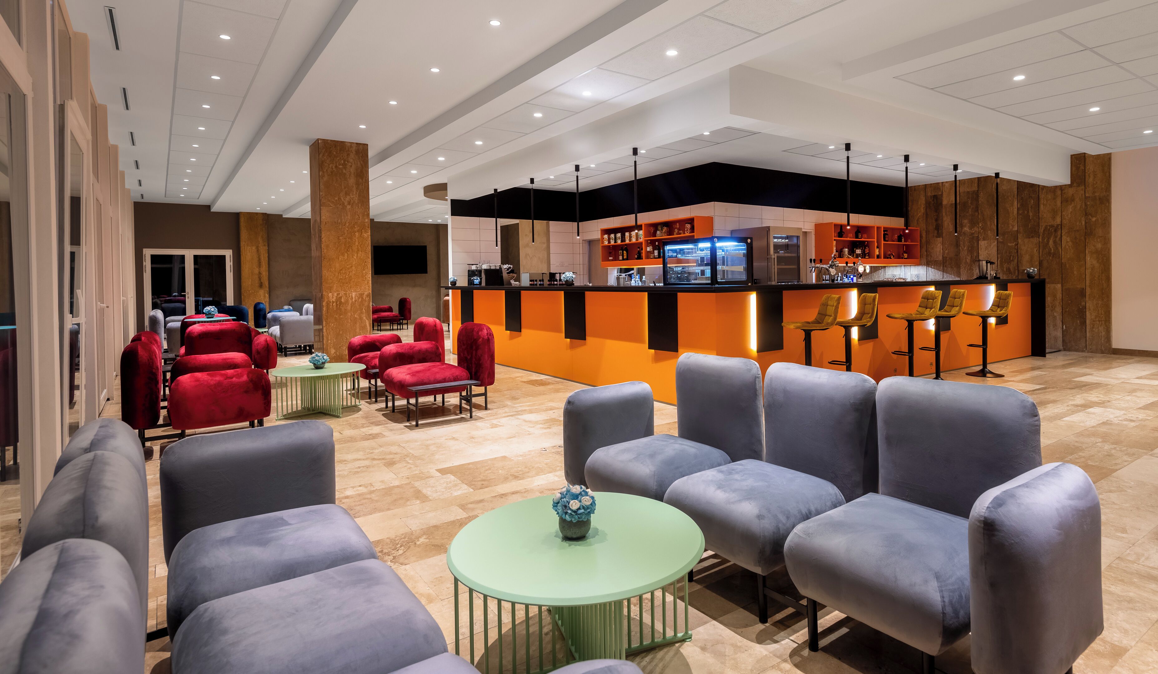 A hotel lobby with seating areas, a bar, and a reception desk.