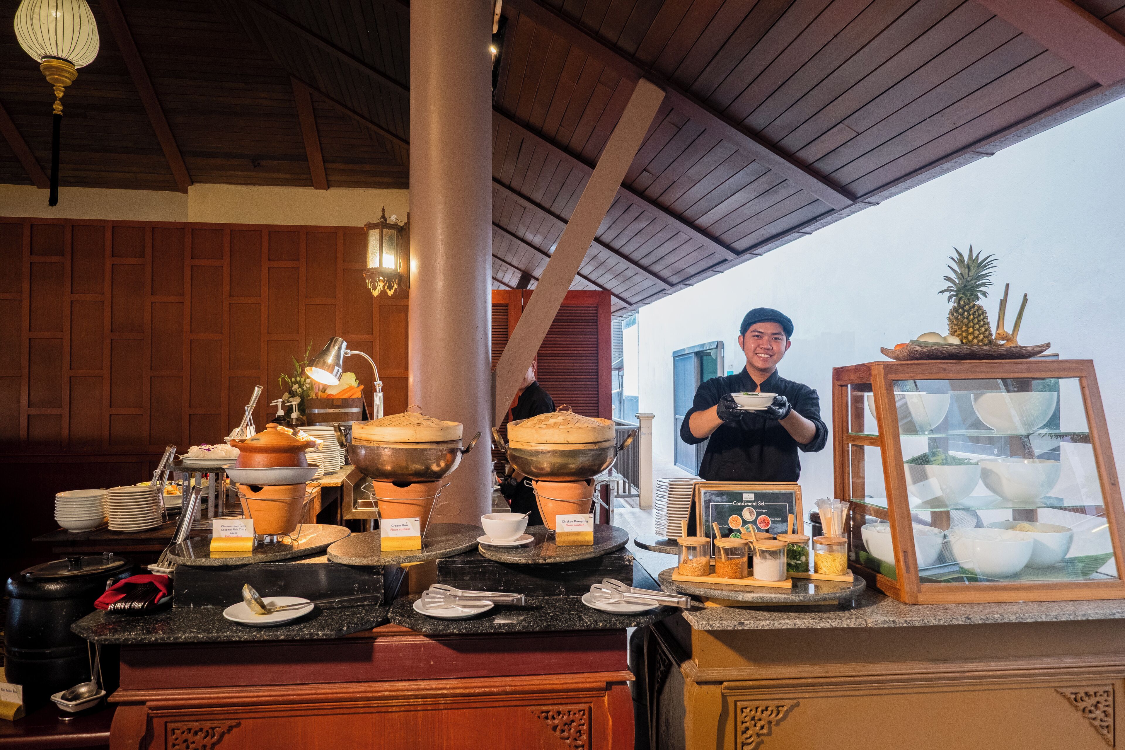 A buffet setup with various food containers and a display case.