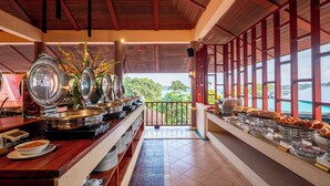 A buffet with various dishes and a view of the outdoors. - Chanalai Garden Resort, Kata Beach (Karon)