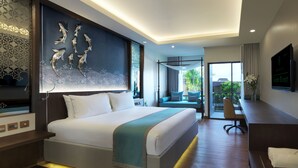 A modern hotel room with a large bed, a desk, and a balcony with a view. - Chanalai Garden Resort, Kata Beach (Karon)