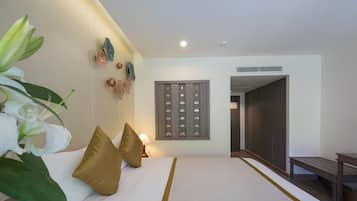 A hotel room with a large bed, a bedside table, a lamp, and a wall-mounted decorative panel.
