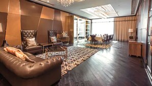 A modern living room with a large sofa, a chandelier, and a dining area. - Cinese Hotel Dongguan (Dongguan)